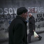 People walk past a mural reading ''Republic of Kosova'' in Pristina on Feb. 27, 2023, as the European Union hosts talks between the rival leaders of Kosovo and Serbia.
