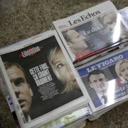 Photos of French President Emmanuel Macron and right-wing candidate Marine Le Pen are displayed on the front pages of French newspapers at a newsstand in Paris on April 11, 2022, after Macron and Le Pen won the most and second-most votes, respectively, in the first round of France's presidential election. 