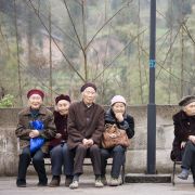Elderly women sit together on benches in Chongqing, China.