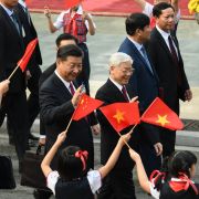 Chinese President Xi Jinping (center) and Vietnam's Communist Party Secretary General Nguyen Phu Trong (right) wave during a welcoming ceremony at the presidential palace in Hanoi, Vietnam, on Nov. 12, 2017. 
