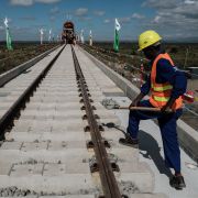 A construction worker adds gravel to the tracks of a section of the new Standard Gauge Railway (SGR) in Nairobi, Kenya, in June 2018. 