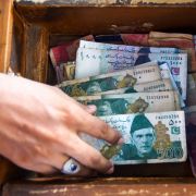 A man counts Pakistani rupees at his shop in Karachi, Pakistan, in May 2019. 