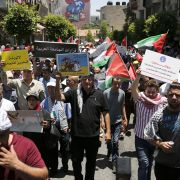 Demonstrators opposed to the U.S.-led plan for Israeli-Palestinian peace march through Ramallah in the West Bank on June 24.