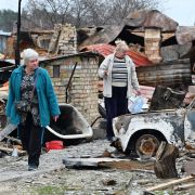 Two women survey their destroyed houses in the Ukrainian village of Moshchun, northwest of Kyiv, on April 20, 2022.