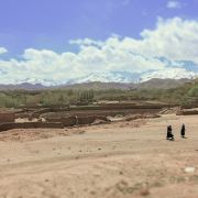 Villagers walk across a striking Afghan rural landscape. 
