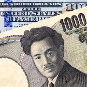 A photo illustration shows a banknote of the Japanese yen overlapping a banknote of the U.S. dollar.