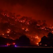 A fire truck drives past a hill engulfed in flames in New South Wales, Australia. A fire truck drives past a hill engulfed in flames on the night of Jan. 20, 2020 in Mount Adrah, Australia. The 2020 fire season has hit the southern coast of New South Wales particularly hard.