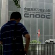 A man stands outside the CNOOC headquarters building in Beijing, China, on July 29, 2016. Targeting China’s third-largest oil company highlights the South China Sea’s importance to U.S. strategy, which is unlikely to change under Biden.