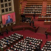 Chinese Premier Li Keqiang speaks on a podium and is seen on a large screen at the opening session of the National People's Congress at the Great Hall of the People on March 5, 2022, in Beijing.