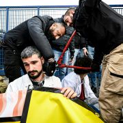Police officers remove a chain Nov. 10, 2022, from the neck of an activist as climate activists block the entrance of the Milano Linate Prime fixed-base operator airport facility in Milan.