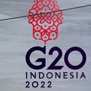 A woman in Jakarta, Indonesia, walks past a logo for the upcoming G-20 Summit in Bali on Nov. 8, 2022. 