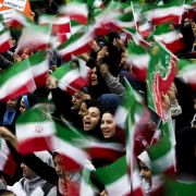 Iranian schoolgirls wave their country's flag at a rally on the anniversary of Iran's Islamic revolution. 