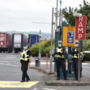 Police officers stand guard as pro-British loyalists protest against the Northern Ireland Protocol at Belfast Harbour on July 3, 2021. Police officers stand guard as pro-British loyalists protest against the Northern Ireland Protocol at Belfast Harbour on July 3, 2021.