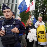 Police stand guard in Warsaw, Poland, as demonstrators holding EU and Polish flags protest the country’s proposed media law on Aug. 10, 2021.
