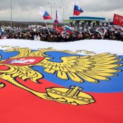 People in a village outside Simferopol, Crimea, hold a giant Russian flag during a rally in support of Russia's ongoing war against Ukraine on March 5, 2022. 