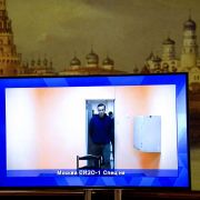 Opposition leader Alexei Navalny on Jan. 28, 2021, appears on a screen set up at a hall of the Moscow Regional Court.