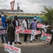 Unemployment in South Africa could worsen if labor unions and the government cannot reach an accord over a wage bill, leading to layoffs. Tradesmen stand on the side of the road in Johannesburg, South Africa, seeking work.